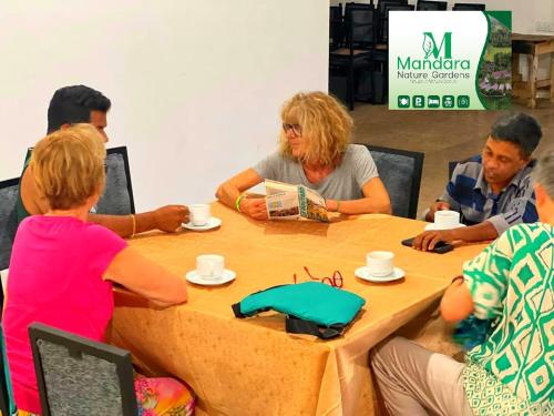 a group of people sitting around a table at Mandara Nature Gardens in Veyangoda