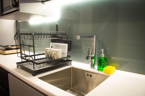 a kitchen sink with a rack over the sink at 6Muji 2room 5min to 1U&Ikea with SkyPool at EmpireCity by Light House in Petaling Jaya