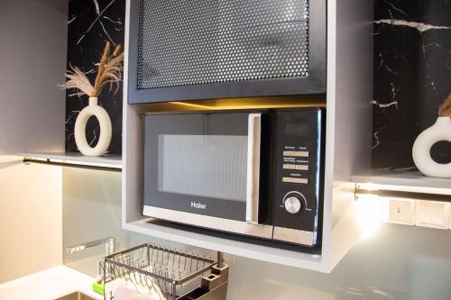 a microwave oven is mounted on a wall at 6Muji 2room 5min to 1U&Ikea with SkyPool at EmpireCity by Light House in Petaling Jaya