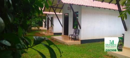 a building with a chair outside of it at Mandara Nature Gardens in Veyangoda