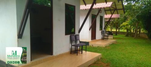 a house with two chairs sitting outside of it at Mandara Nature Gardens in Veyangoda