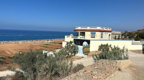 a building on a hill next to the ocean at Villa MANSOURA in Driouch