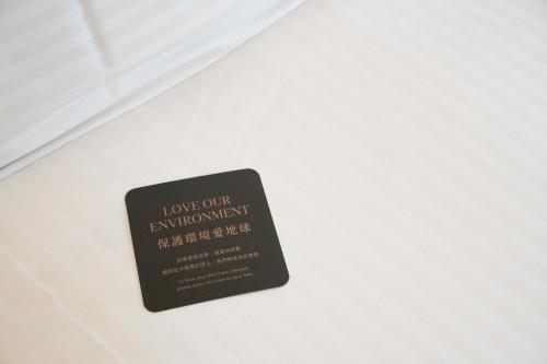 a black sign on a white bedsheet at 塔木德酒店 台中火車站館 Talmud Hotel Taichung Station in Taichung
