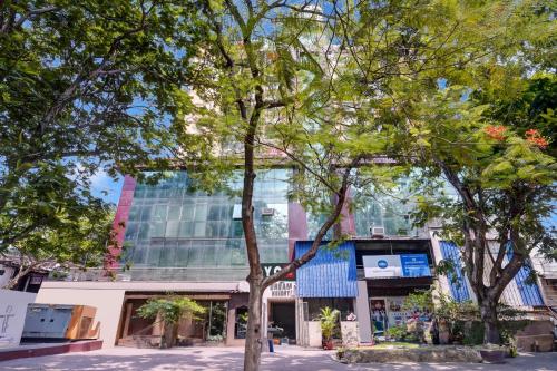 a tall building with trees in front of it at Super Hotel O DEGREE HOTEL in Jamshedpur