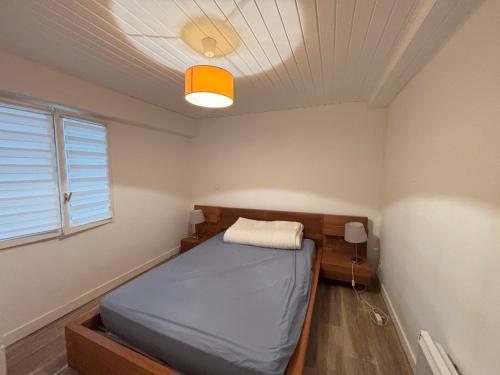 une chambre avec un lit et une lumière au plafond dans l'établissement Maison 2 chambres, accès direct plage, centre-ville des Sables-d'Olonne - FR-1-197-356, à Les Sables-dʼOlonne