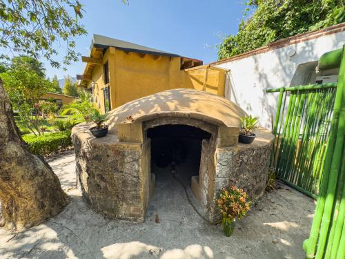 a stone oven with potted plants in a yard at Hotel Boutique Bacaanda in Tepoztlán