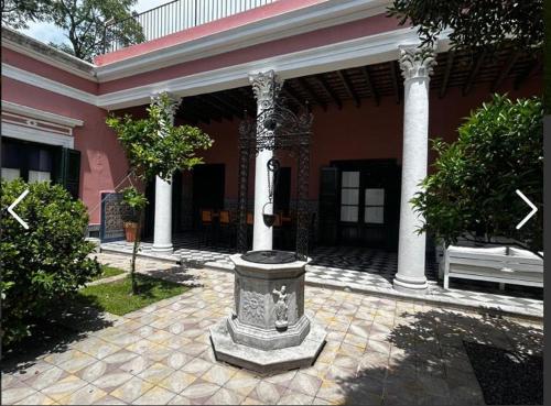 a building with a fountain in the middle of a courtyard at Las Flores in San Isidro