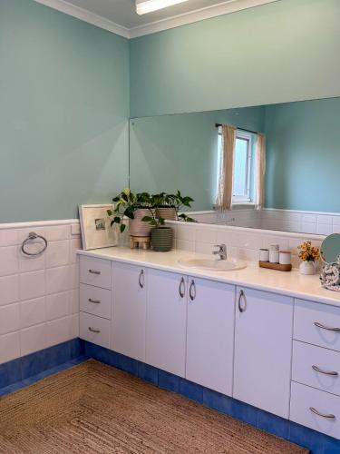 a bathroom with a sink and a mirror at Océane Beach House Marion Bay South Australia in Marion Bay