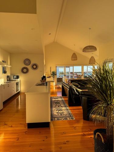 a kitchen and living room with a couch and a table at Océane Beach House Marion Bay South Australia in Marion Bay
