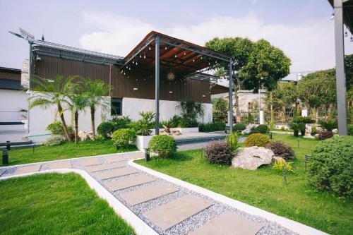 a garden with a stone walkway in front of a building at Khoai Mật Homestay in Mộc Châu