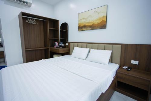 a bedroom with a large white bed in a room at Khoai Mật Homestay in Mộc Châu