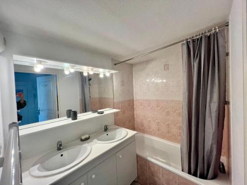 une salle de bain avec deux lavabos, un miroir et une baignoire dans l'établissement Duplex T3 avec parking privé, près du port à La Teste de Buch - FR-1-319-587, à La Teste-de-Buch