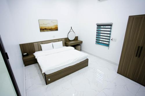 a bedroom with a bed and a mirror on the wall at Khoai Mật Homestay in Mộc Châu
