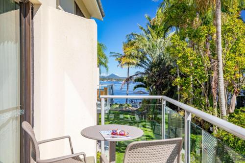 a balcony with a table and chairs and a view of the water at Culgoa Point Beach Resort in Noosa Heads
