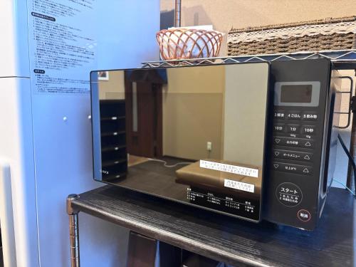 a microwave oven sitting on top of a table at Hotel Route-Inn Iyo-Saijo in Saijo