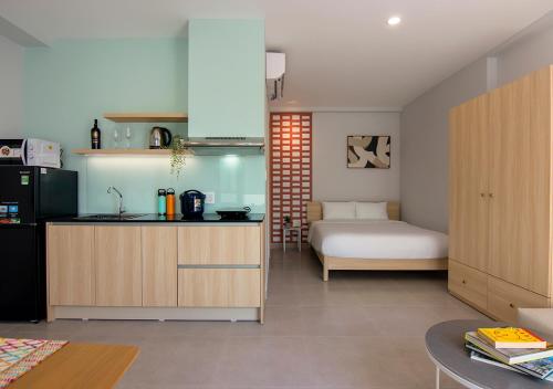 a kitchen with a sink and a bed in a room at ORA Serviced Apartments - Binh Duong New City in Thu Dau Mot