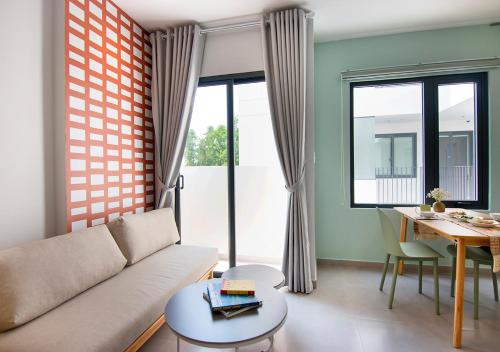a living room with a couch and a table at ORA Serviced Apartments - Binh Duong New City in Thu Dau Mot
