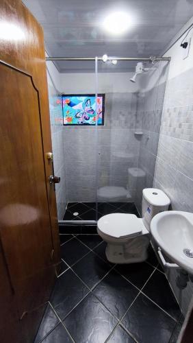 a bathroom with a shower and a toilet and a sink at Choachi casa colibri in Choachí