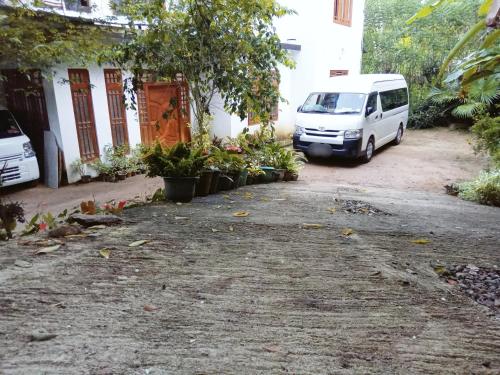 a white van parked in front of a building at Uduwara Holiday Home in Badulla