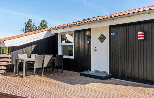 a wooden deck with a table and chairs on a house at Beautiful Home In Thisted With Kitchen in Thisted