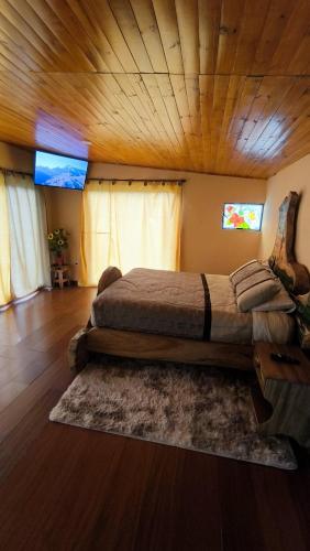 a large bed in a room with a wooden ceiling at Choachi casa colibri in Choachí