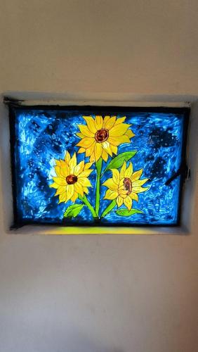 a stained glass window with yellow flowers on a wall at Choachi casa colibri in Choachí