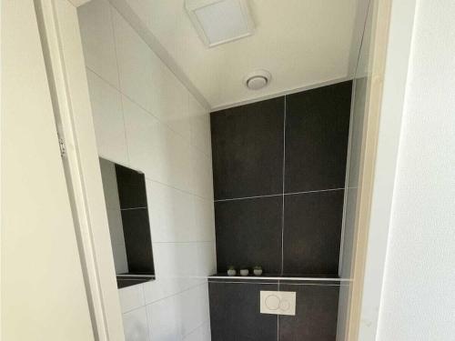 bagno con doccia e piastrelle bianche e nere di "Sunkiss at the IJsselmeer" a Enkhuizen