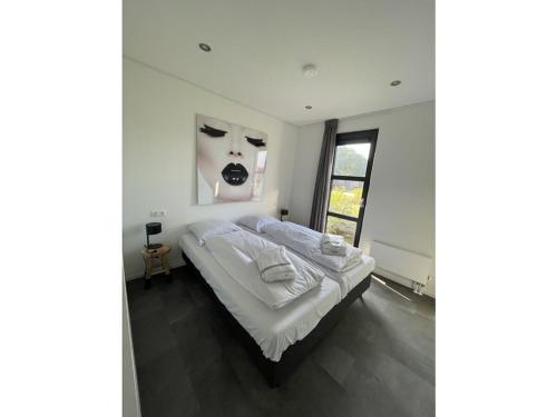 una camera con un letto e una foto di una donna di "Sunkiss at the IJsselmeer" a Enkhuizen