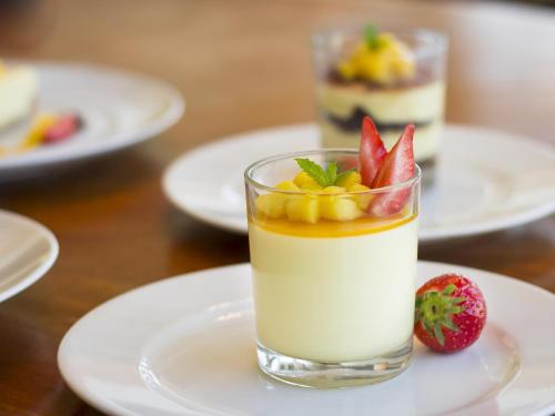 a glass of milk with fruit on a plate at Kempinski Hotel Gold Coast City in Accra