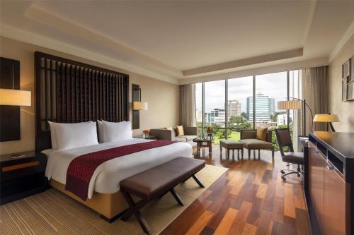 a hotel room with a bed and a large window at Kempinski Hotel Gold Coast City in Accra