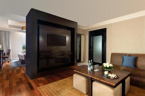 a living room with a large flat screen tv at Kempinski Hotel Gold Coast City in Accra
