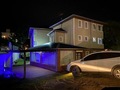 un coche aparcado frente a una casa con luces azules en Valeria Costa y Mar, en Valeria del Mar