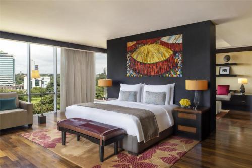 a bedroom with a large bed and a large window at Kempinski Hotel Gold Coast City in Accra