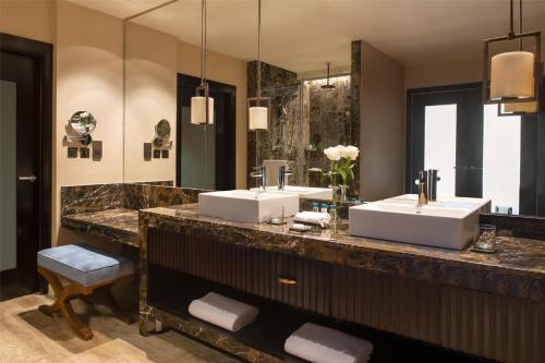 a bathroom with two sinks and a large mirror at Kempinski Hotel Gold Coast City in Accra