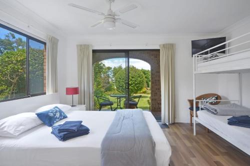 une chambre avec deux lits et une grande fenêtre dans l'établissement Baycation House Huskisson, à Huskisson