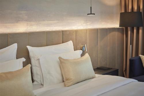 a bedroom with a bed with white pillows at Hotel Kempinski Palace Portorož in Portorož
