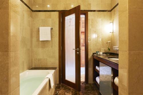 a bathroom with a bath tub and a sink at Hotel Kempinski Palace Portorož in Portorož