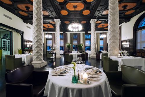 a dining room with white tables and chairs at Hotel Kempinski Palace Portorož in Portorož