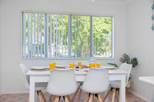 a white dining room with a white table and white chairs at Holiday Haven @ North Haven - club, river, beach in North Haven
