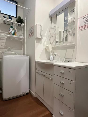 a white bathroom with a sink and a mirror at INUYAMA BASE Vacation rental in Inuyama