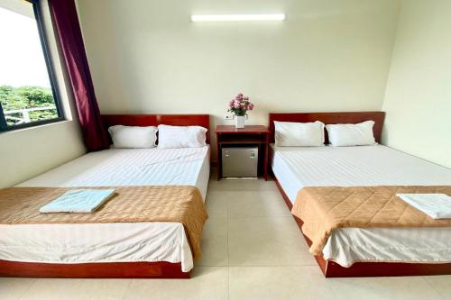 two beds in a hotel room with at Khách Sạn Thành Trung Vàn Chảy in Quang Ninh