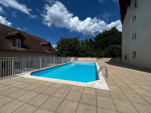 - une piscine dans une cour à côté d'un bâtiment dans l'établissement T2 rénové avec piscine chauffée proche Thermes, parking et WIFI - FR-1-541-164, à La Roche-Posay
