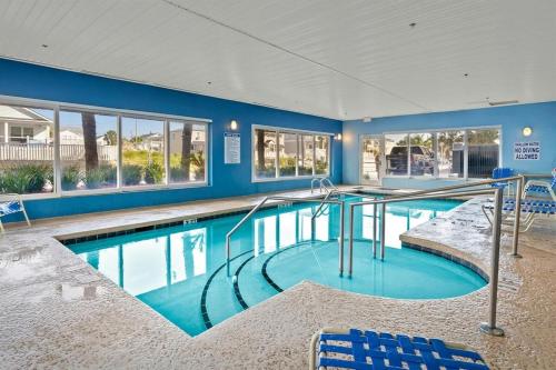 a large swimming pool with blue chairs in a building at Oceanfront Crescent Shores #208-Sleeps 10 3bed 3bath 28 Foot Balcony in North Myrtle Beach