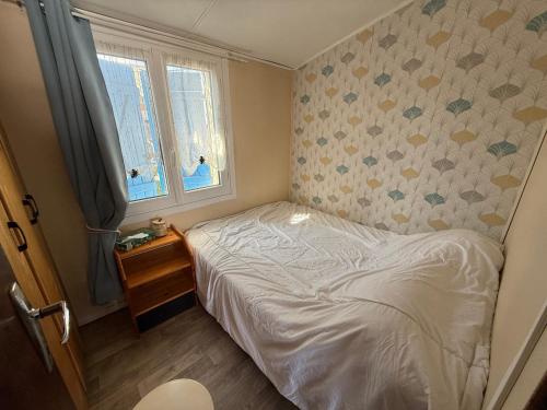 une petite chambre avec un lit et une fenêtre dans l'établissement Chalet à Gruissan pour 8 pers, confort et charme - FR-1-784-41, à Gruissan