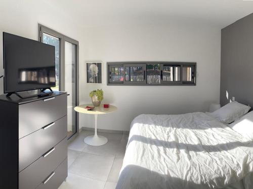 a bedroom with a bed and a tv and a table at Maison de vacances à Mimizan Plage - Confort moderne proche océan - FR-1-50-177 in Mimizan
