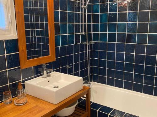 une salle de bain carrelée bleue avec un lavabo et une baignoire dans l'établissement Mas 2 chambres avec terrasse et jardin privatif - FR-1-726-61, à La Croix-Valmer