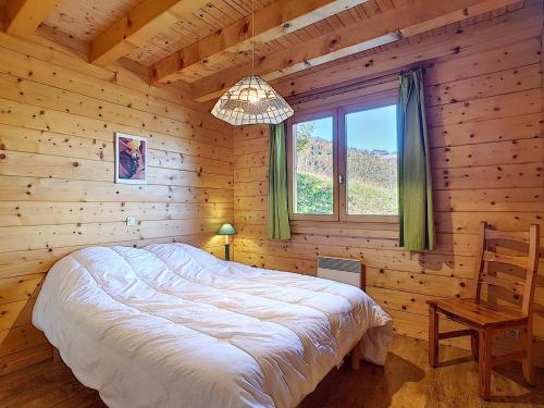 une chambre avec un lit dans une cabane en bois dans l'établissement Demi-chalet cosy à La Clusaz pour 6 pers, cheminée, animaux admis, WiFi - FR-1-818-102, à La Clusaz