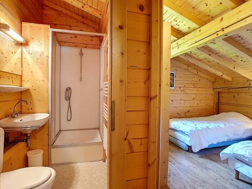 - une salle de bains avec un lit et un lavabo dans une cabane en rondins dans l'établissement Demi-chalet cosy à La Clusaz pour 6 pers, cheminée, animaux admis, WiFi - FR-1-818-102, à La Clusaz