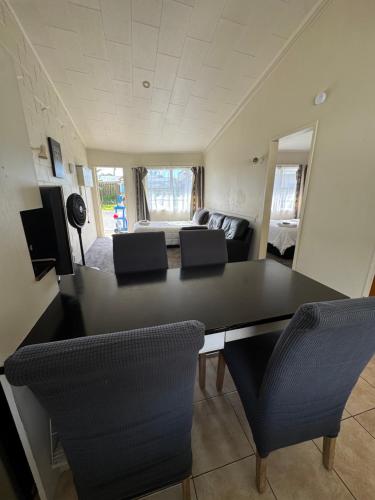 a living room with a black table and chairs at Fountain Court Motel in Tauranga