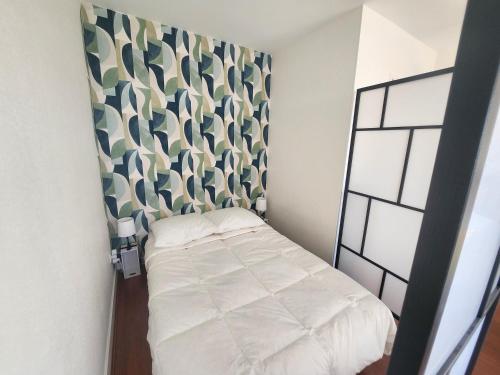une petite chambre avec un lit dans une pièce dans l'établissement Grand studio lumineux avec parking privé à Courseulles-sur-Mer - FR-1-746-29, à Courseulles-sur-Mer